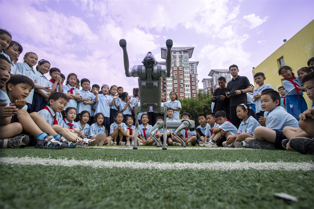 6月14日，河北省邯鄲市復興區前進小學操場，學生們與機器狗打招呼。聶長青攝