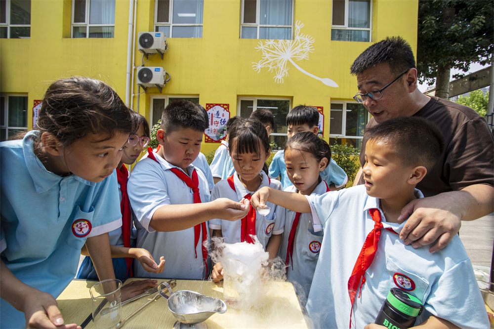 6月14日，河北省邯郸市复兴区前进小学操场，学生们在老师指导下体验腾云驾雾的干冰实验。聂长青摄