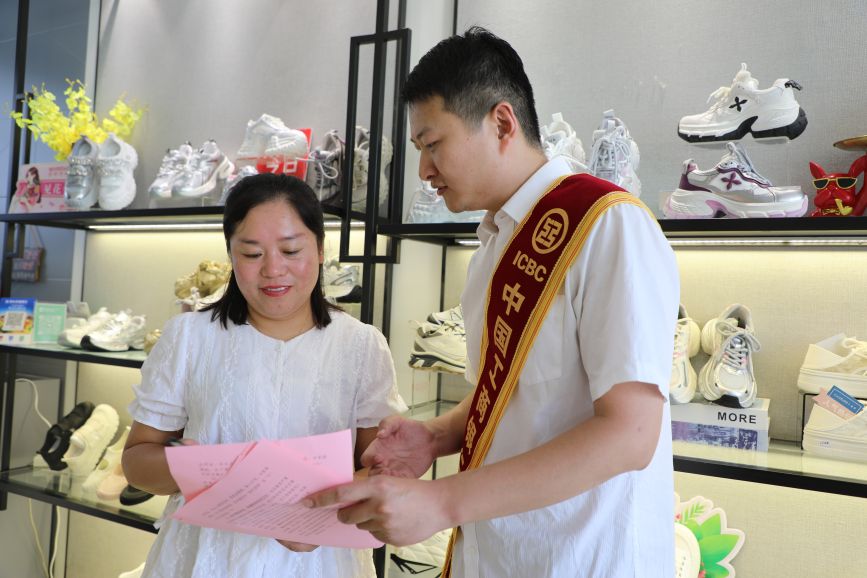 工作人員走進商家為群眾介紹如何防范網絡金融詐騙。徐梓鈺攝