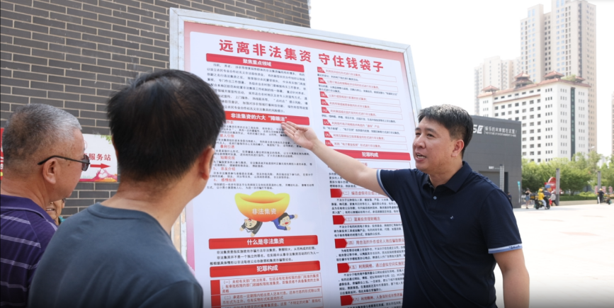 工作人員利用展板向市民講解防范非法集資相關知識。楊晨攝