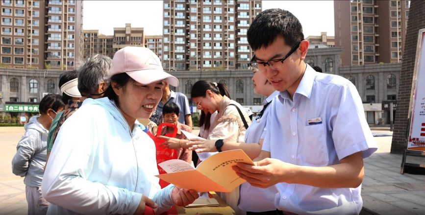 在滄州市新華區鼓樓文化廣場上，工作人員為往來市民講解防范非法集資相關知識。楊晨攝