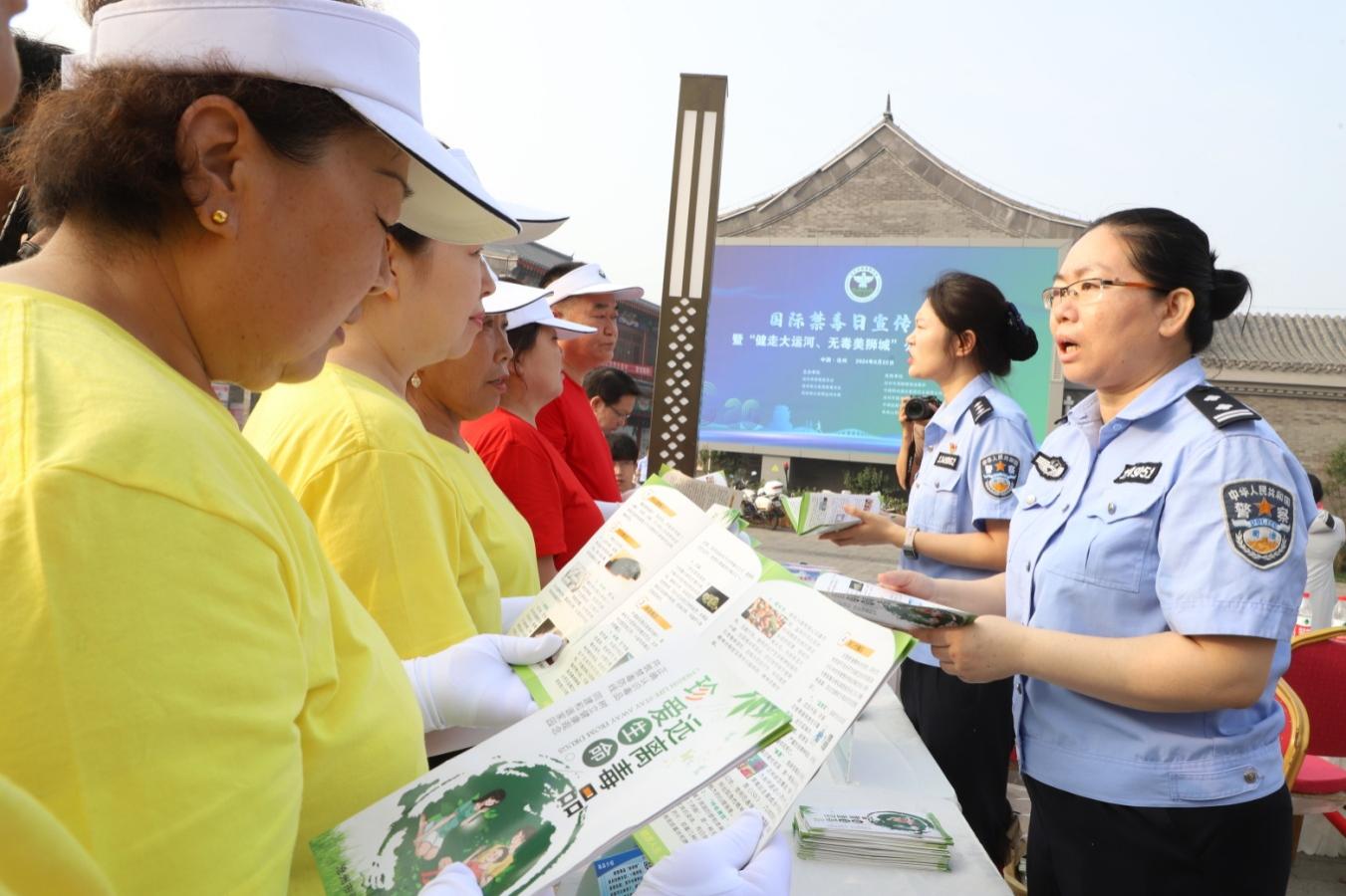 工作人員向健步走隊員宣傳禁毒知識。陳雷攝