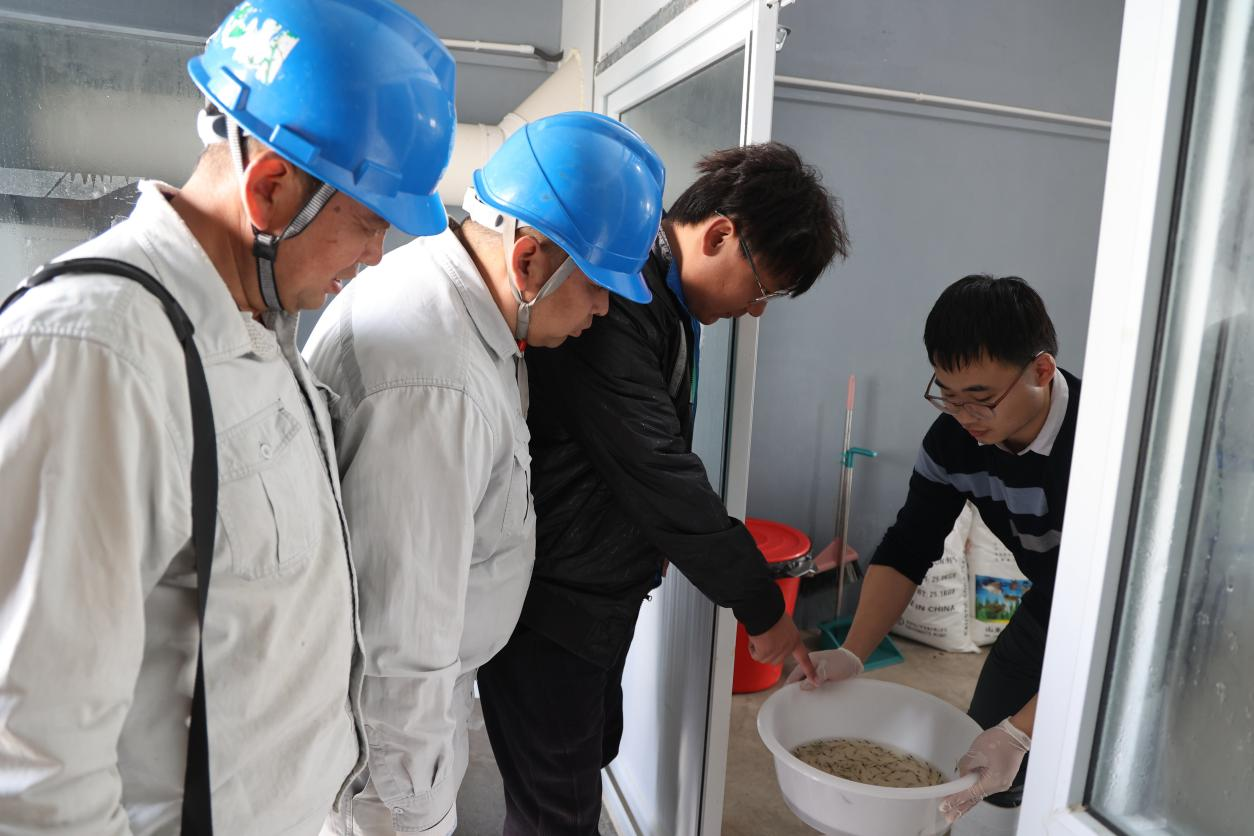 黑沿子供电所的电力工人向养殖户了解生产需求。周宇翔摄
