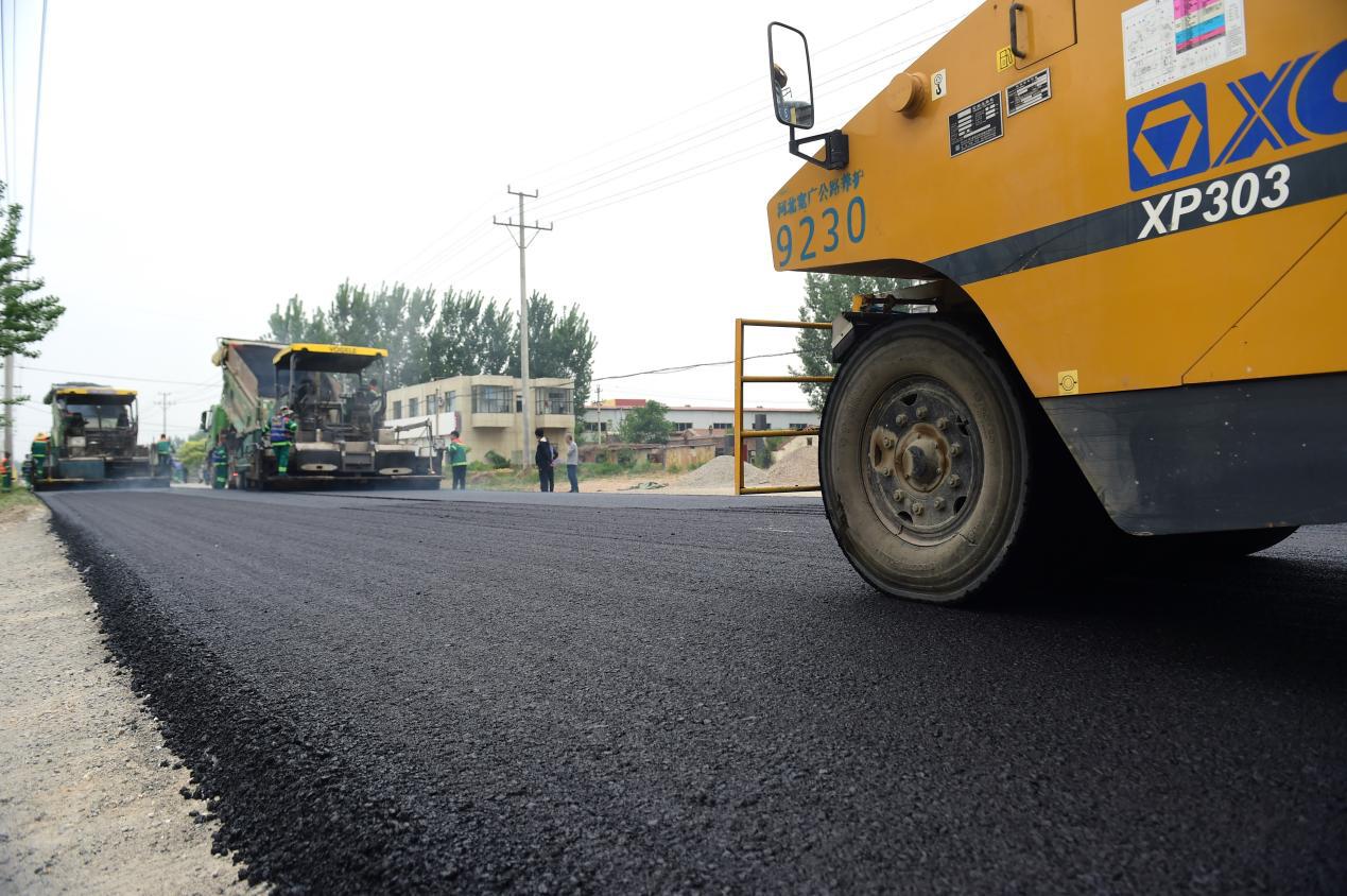 铺路设备进行最后一段公路施工作业。傅新春摄