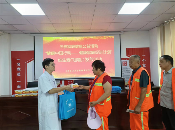 在大名县卫校附属医院,医务工作者在为环卫工人发放维生素C咀嚼片。梁青青摄