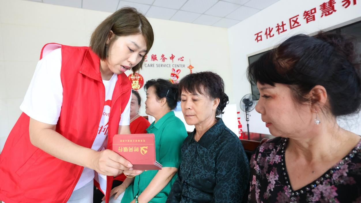 工作人员向社区居民展示“时间银行卡”中的积分数量。张子衡摄