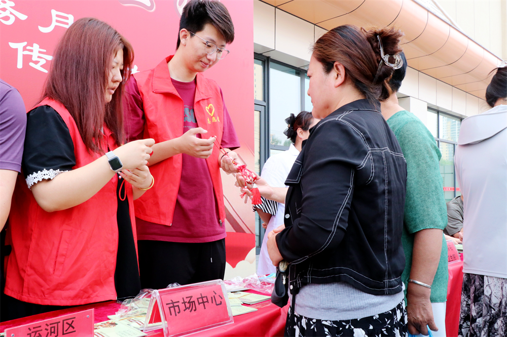 工作人员为居民发放中草药香囊。王杰摄