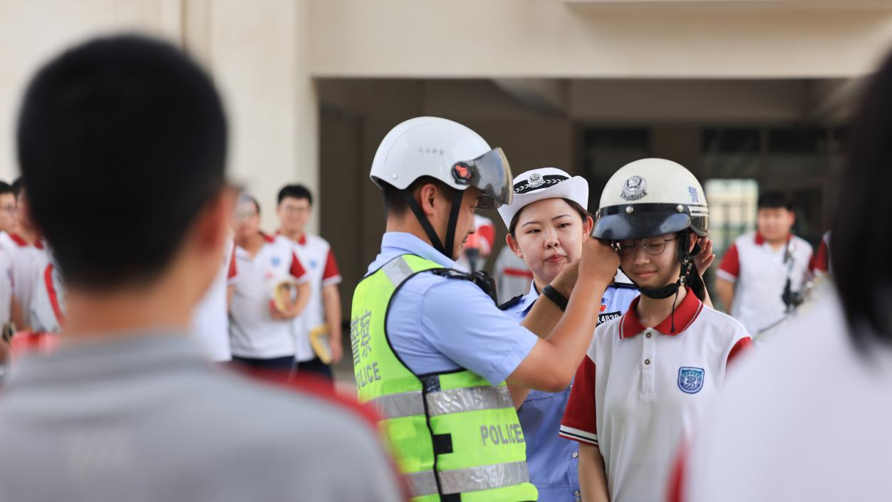 7月23日,易县公安局宣教民警为同学们示范如何正确佩戴安全头盔。杨增红摄