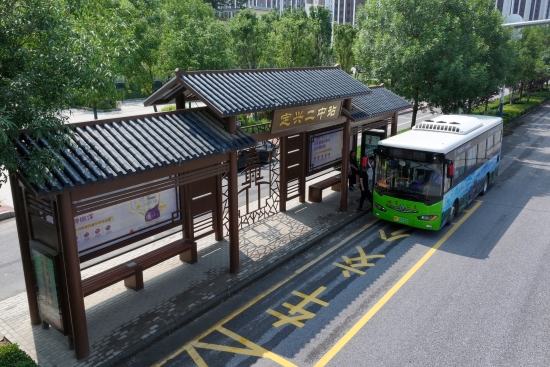仿古式候車亭內，乘客有序上車。張曾良攝