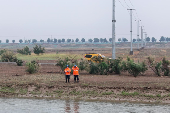 國網晉州市供電公司工作人員對滹沱河沿線10千伏線路開展雨中特巡。彭磊攝