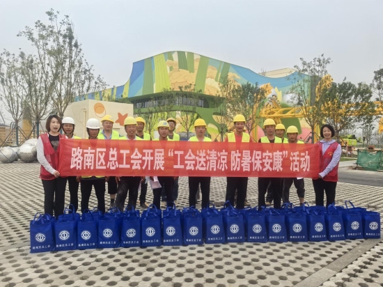 工作人員為米粒王國項目建設工人送上消暑物資。李嘉攝