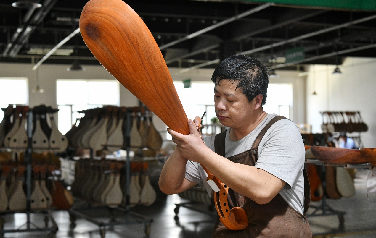 近日，工人在肅寧縣一家樂器企業生產車間制作琵琶。苑立偉攝