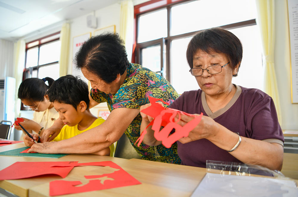 居民认真创作剪纸作品。张明骏摄