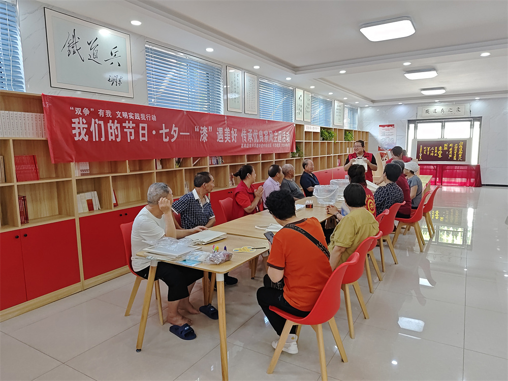 在河北省高碑店市中铁社区活动室，工作人员为居民介绍了漆包和古法造纸术的技艺特点。王梓涵摄