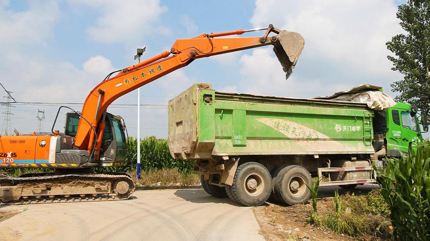 大型機械正在將清理的路石進行裝運。趙宇攝