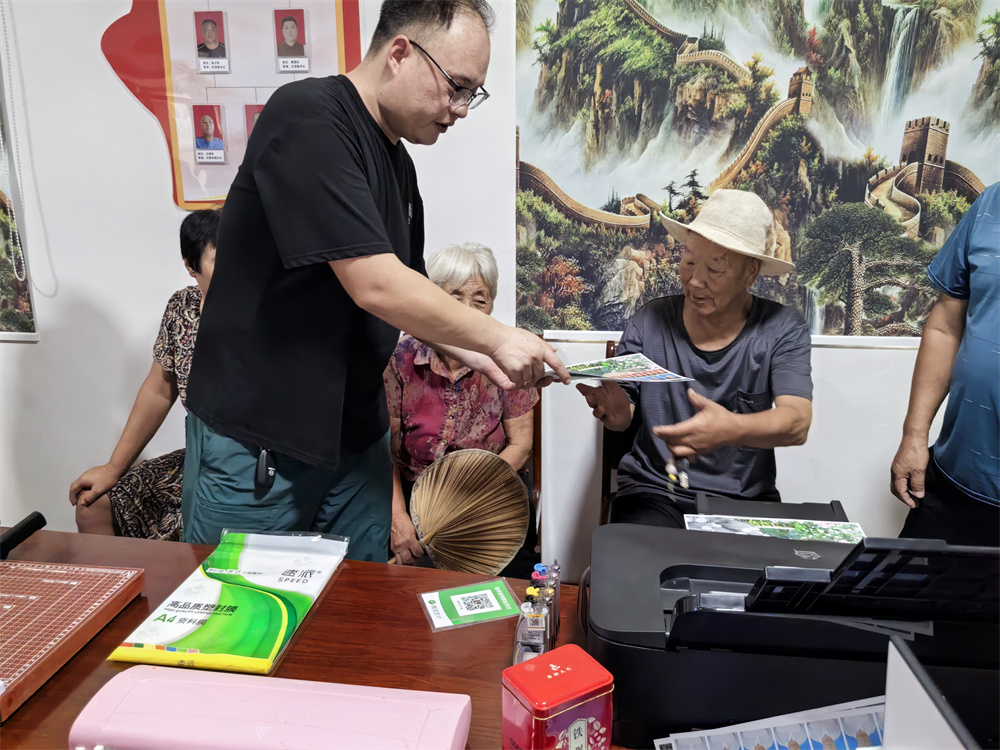 工作人员将照片递到老人手中。马琳碧摄