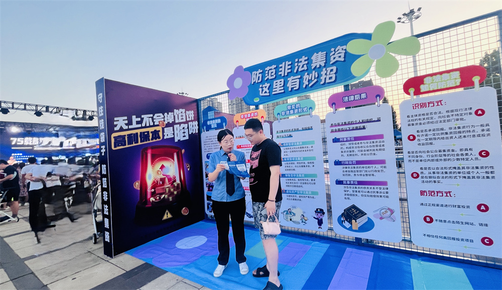 工作人员正在向群众讲解非法集资的危害。徐梓钰摄