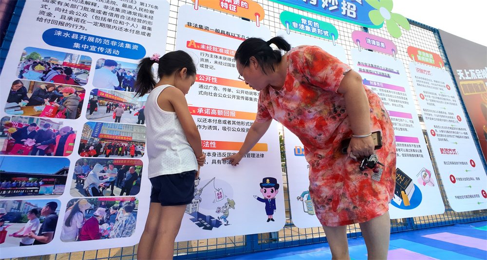 群众正在观看宣传展板。何可人摄