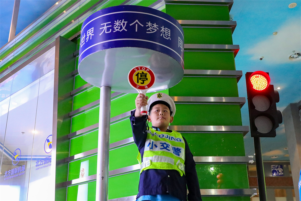 8月13日，學生扮演小交警指揮交通。王穎攝