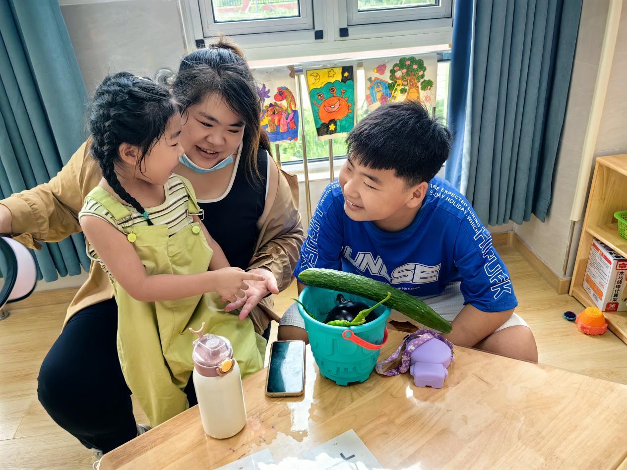 孩子们与家人分享自己采摘的蔬菜。尹阳年摄