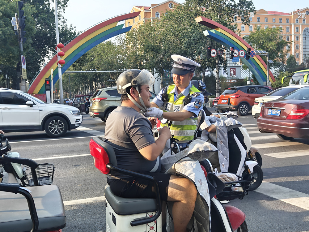 交警在燕郊迎賓路口為群眾講解“一盔一帶”的重要性。張飛虎攝