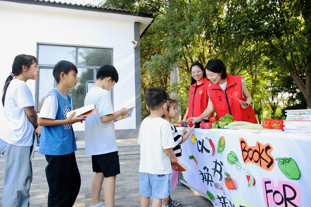 小朋友们参加“以书换蔬”阅读活动。刘巨雷摄