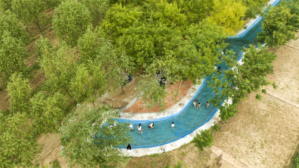 8月25日，河北省邯郸市复兴区康庄乡东望庄村，游客在村里的游泳池嬉戏游玩。聂长青摄