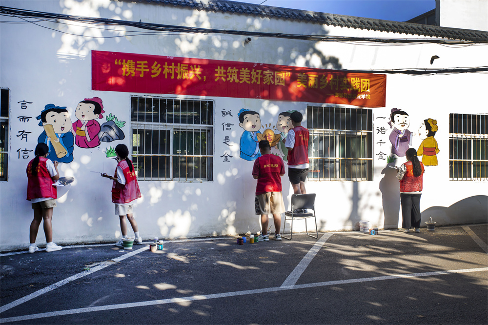 8月27日，河北省邯郸市复兴区化林路街道岭北三社区，邯郸科技职业学院师生在墙绘邯郸成语。聂长青摄