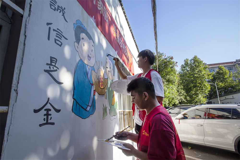 8月27日，河北省邯郸市复兴区化林路街道岭北三社区，邯郸科技职业学院师生在墙绘邯郸成语。聂长青摄