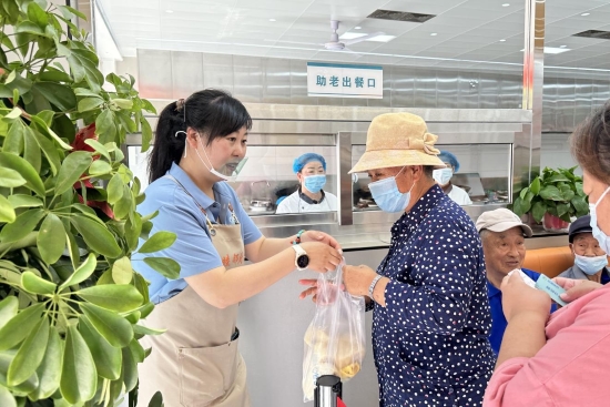 居民在梁家屯路街道社區“睦鄰食堂”購買午餐。唐歆堯攝