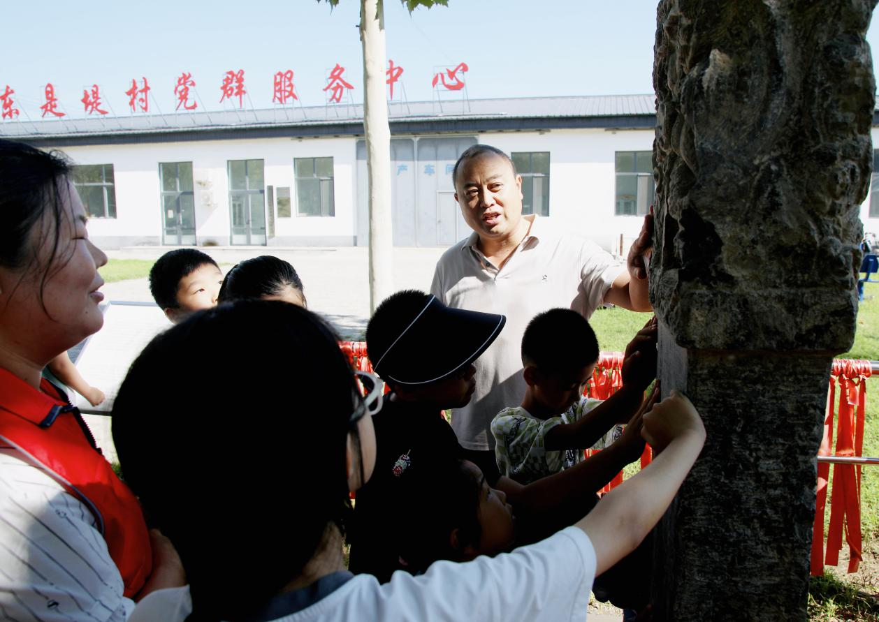 學生在東是堤村參觀教澤碑。劉天宇攝