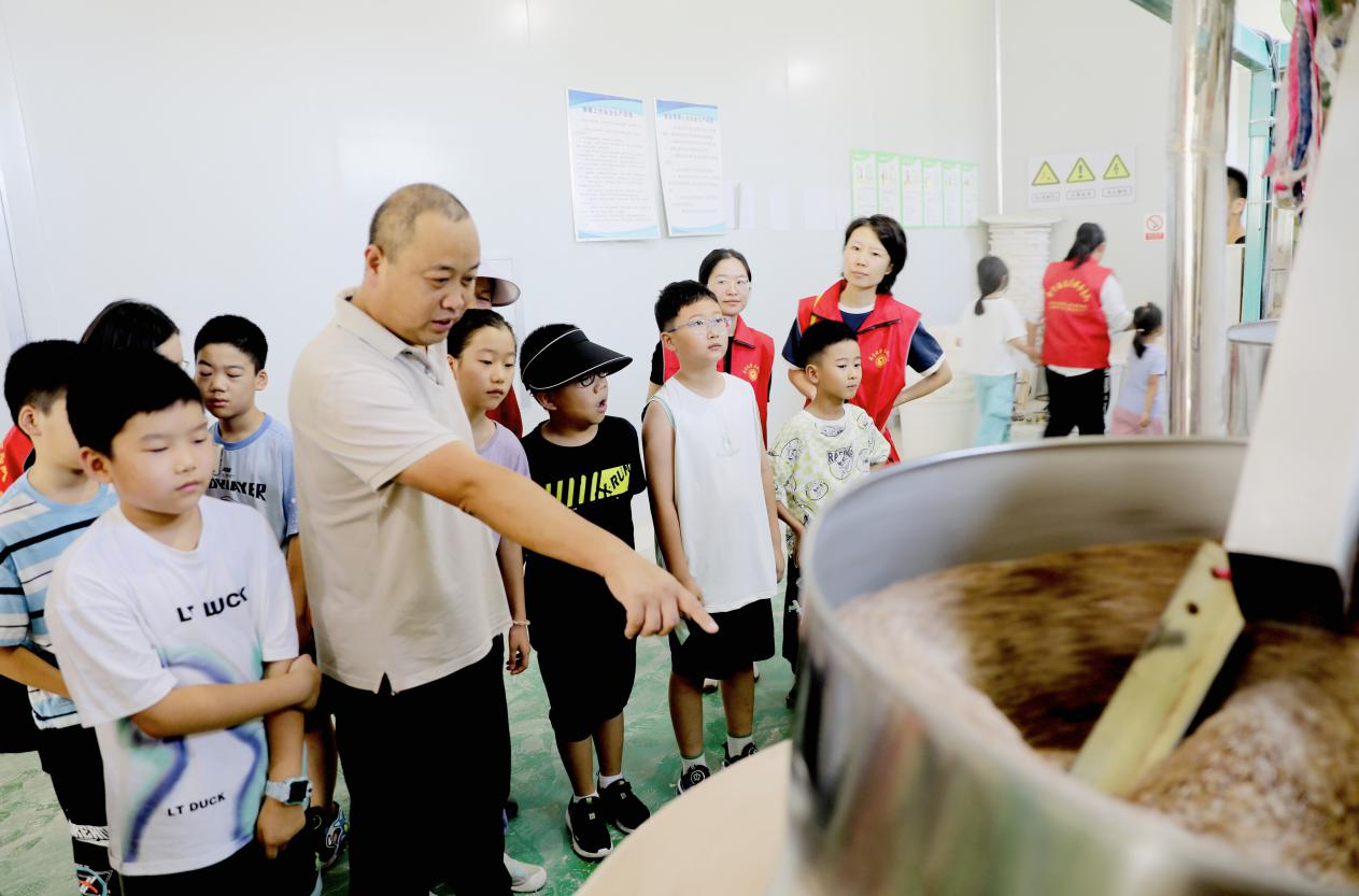 学生在东是堤村参观黑小麦石磨面粉车间。刘天宇摄