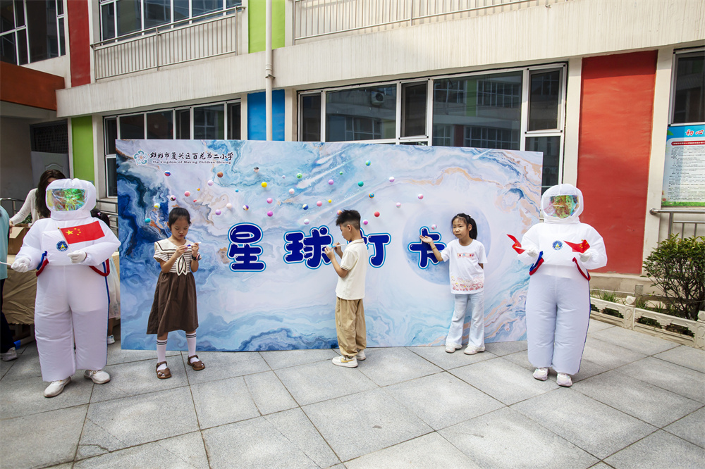 8月31日，河北省邯郸市复兴区百花第二小学，一年级学生在太空展板前描绘自己心目中的星球。聂长青摄