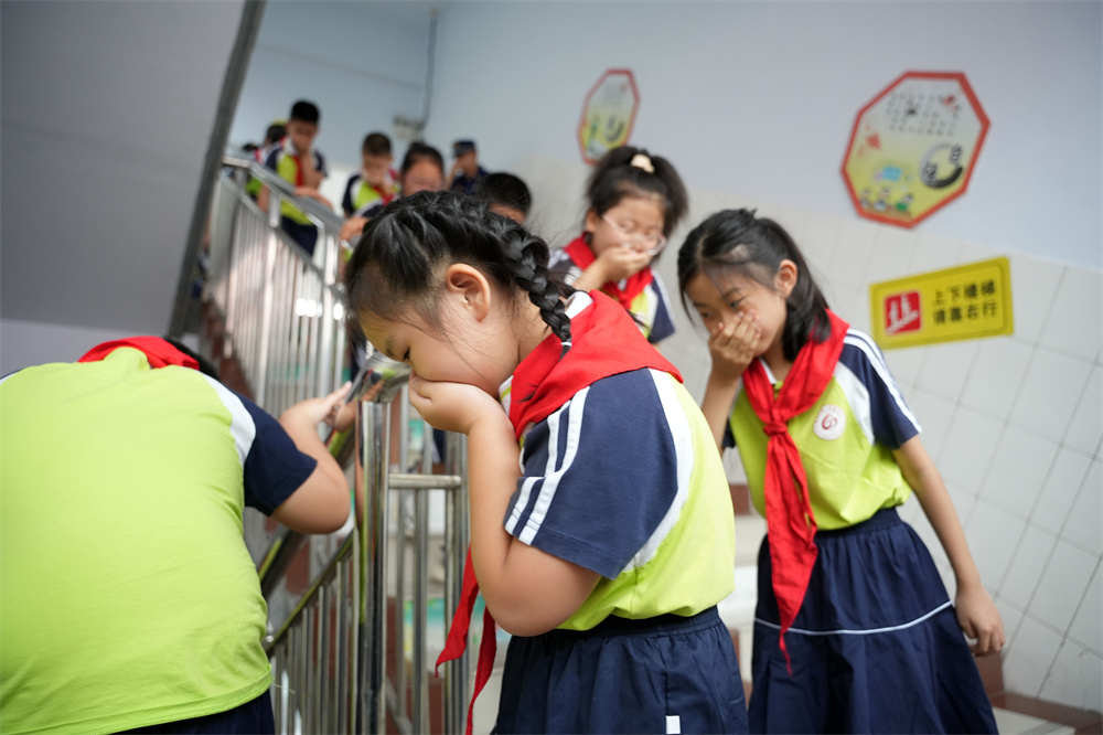 9月1日，河北省隆堯縣第二實驗小學消防安全第一課活動現場，學生們在消防員的指導下進行消防逃生演練。王鑠攝