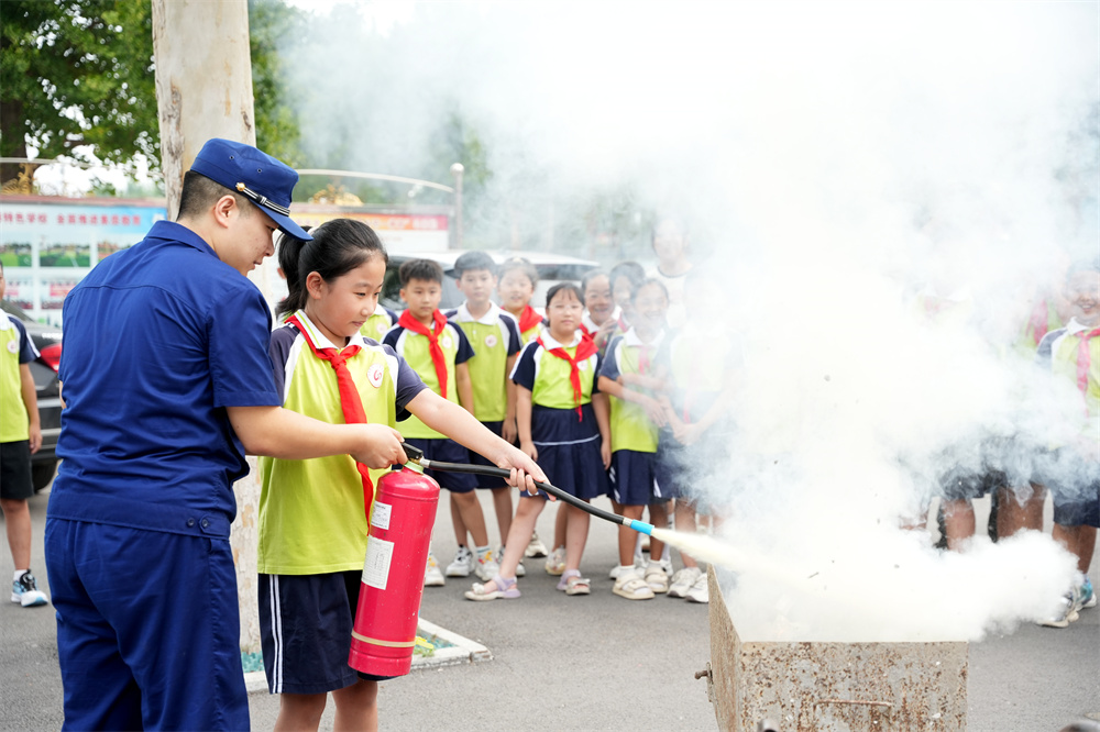9月1日，河北省隆堯縣第二實驗小學消防安全第一課活動現場，學生在消防員的指導下使用干粉滅火器滅火。王鑠攝