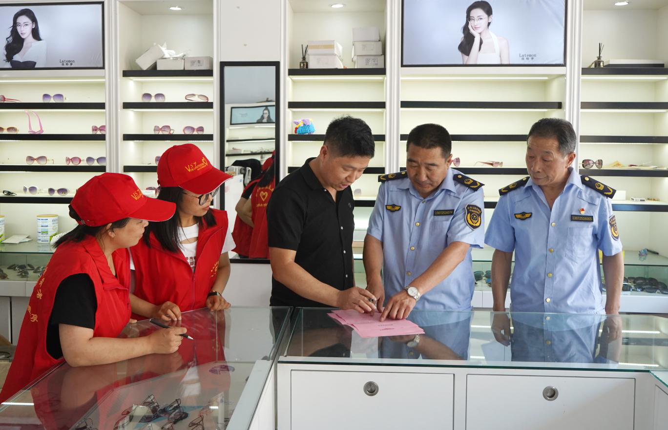工作人员和志愿者到眼镜店进行宣传。刘世伟摄