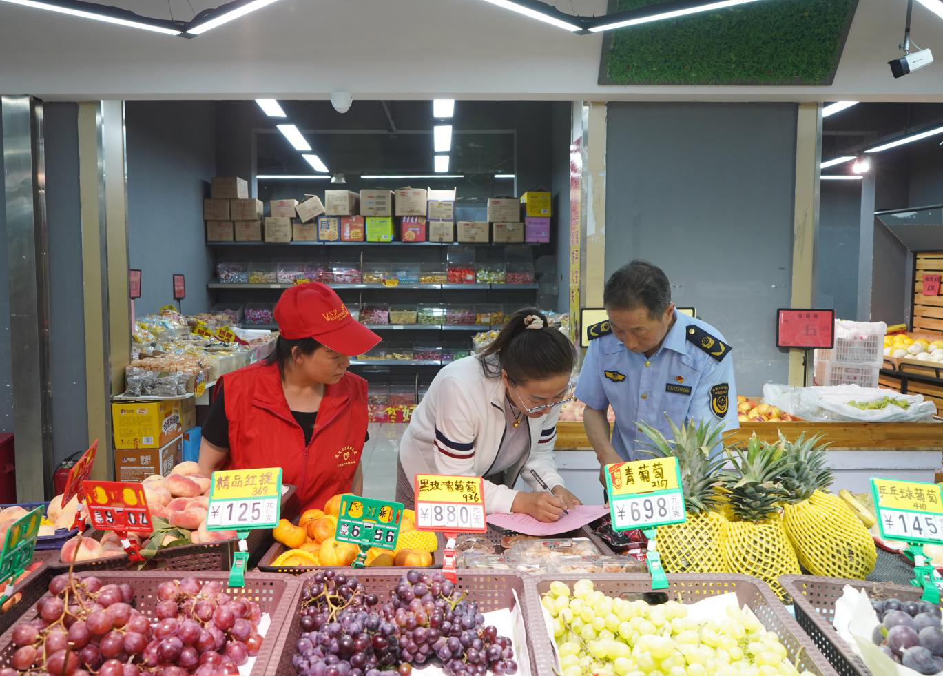 工作人员和志愿者到水果店进行宣传。刘世伟摄