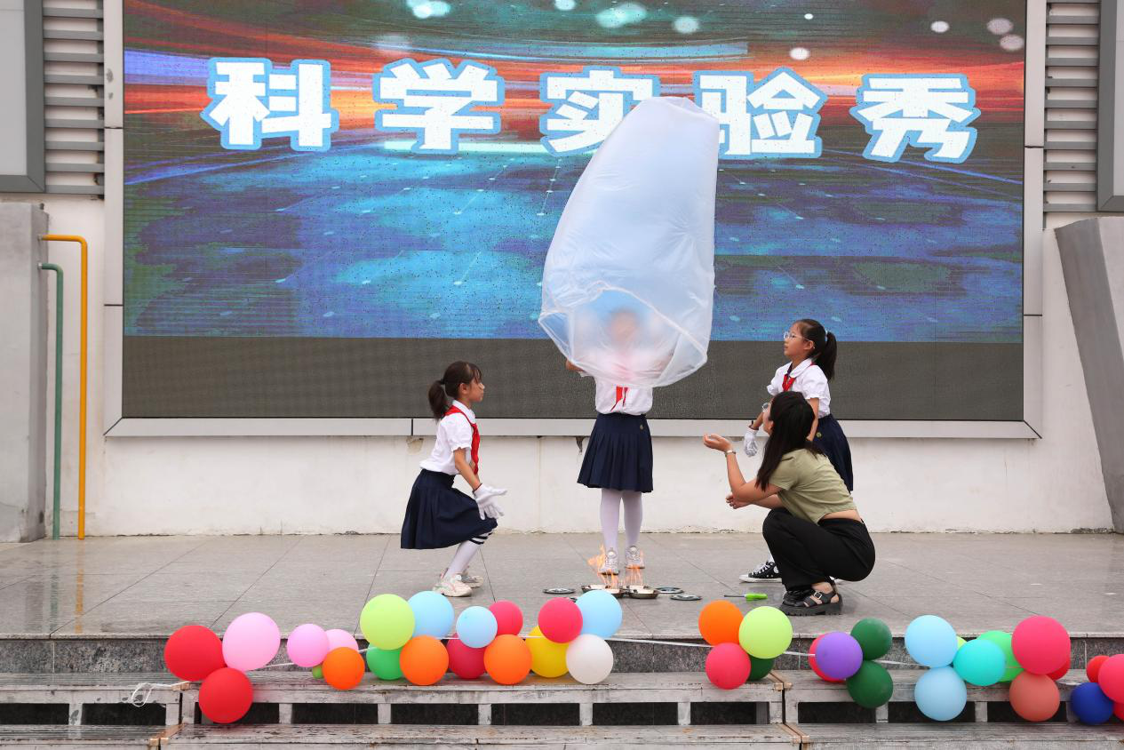 在沧州市路华小学开展的科学实验秀上，学生们与老师一起做“热气球”实验。白雪摄