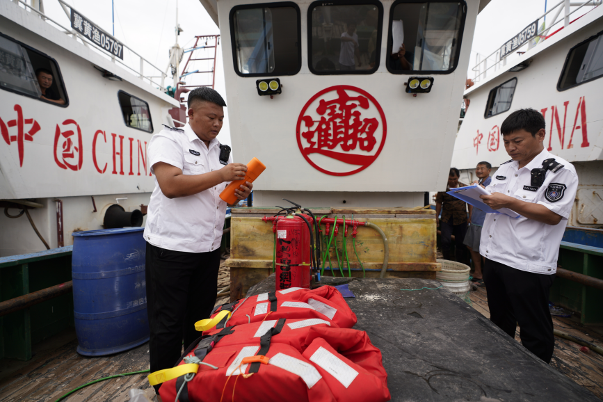 9月1日，在沧州渤海新区黄骅市南排河中心渔港内，出海前，渔政站执法人员在对船只安全进行检查。张国文摄