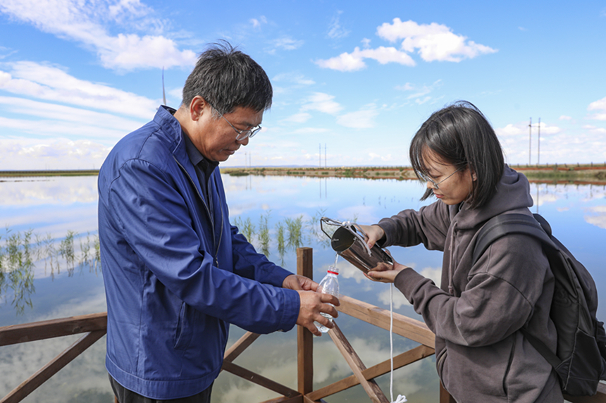 中国科学院农业资源研究中心专家在察汗淖尔湿地公园取水样进行地表水水体面积和水质变化检测。武殿森摄