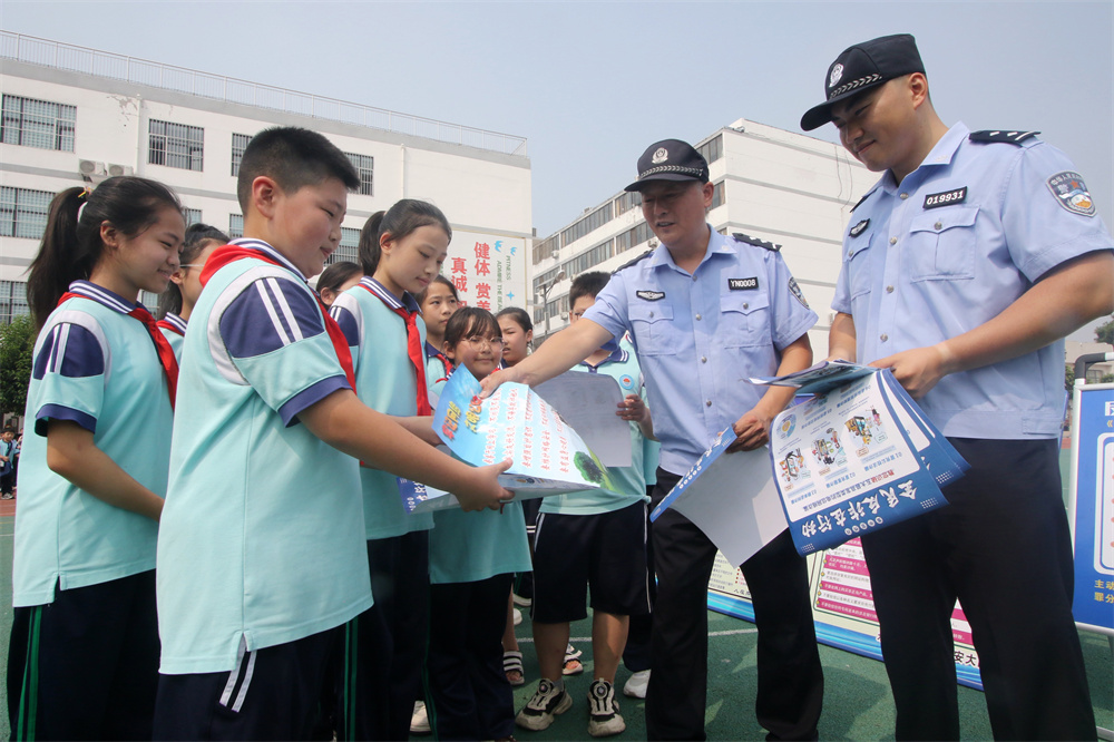 9月9日，在河北省邯郸市永年区第二实验学校，永年区公安局民警正在向学生发放网络安全宣传资料。胡高雷摄