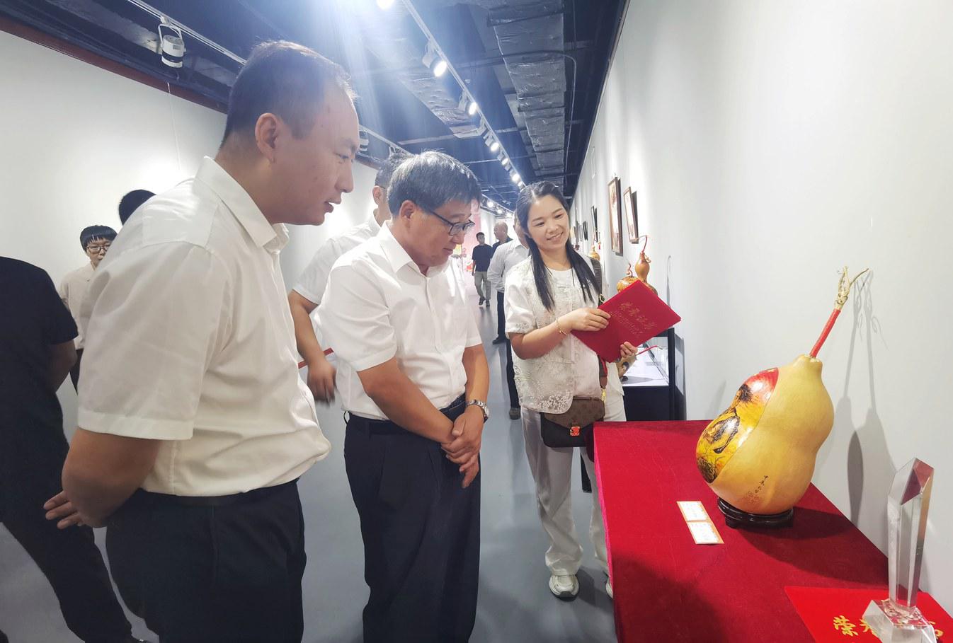 获奖作者李翠云给观众介绍作品《葫芦烙画——小兵张嘎》。金洁摄