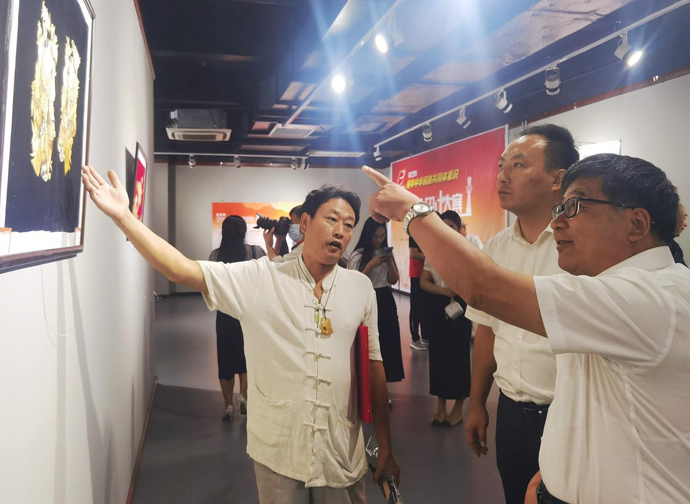 获奖作者周宝鄂给观众介绍作品《白洋淀芦苇画》。金洁摄