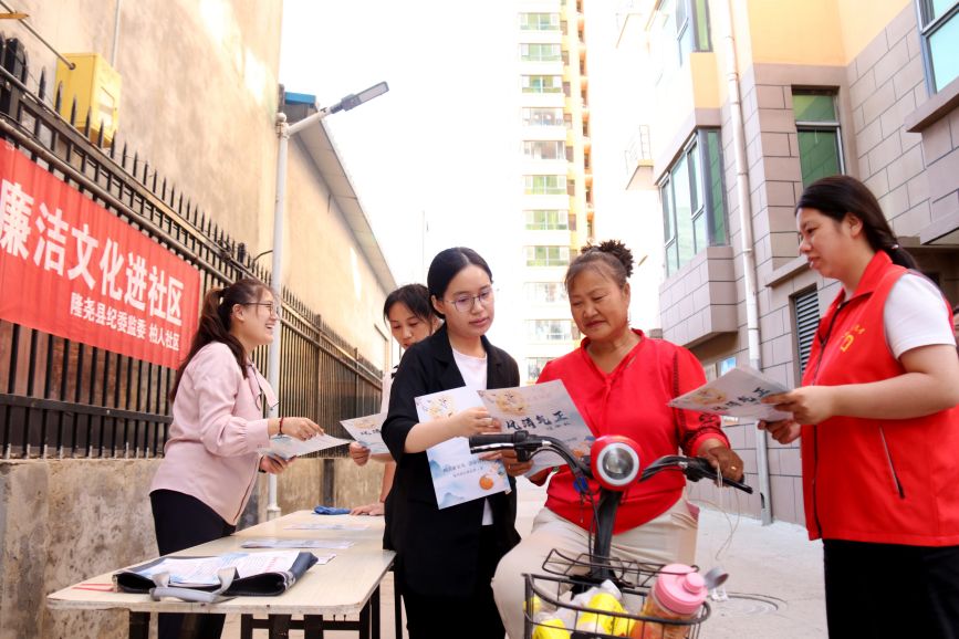 隆堯縣一小區內，紀檢監察干部與社區干部向群眾發放廉潔家風宣傳冊。卜君蘭攝