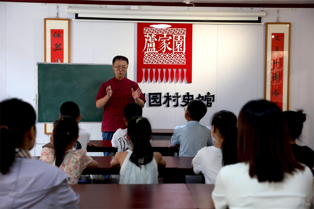 在沧州市新华区芦家园乡村书吧内，沧州区域文化研究所所长孙建为前来阅读的孩子们讲解村史故事。杨晨摄