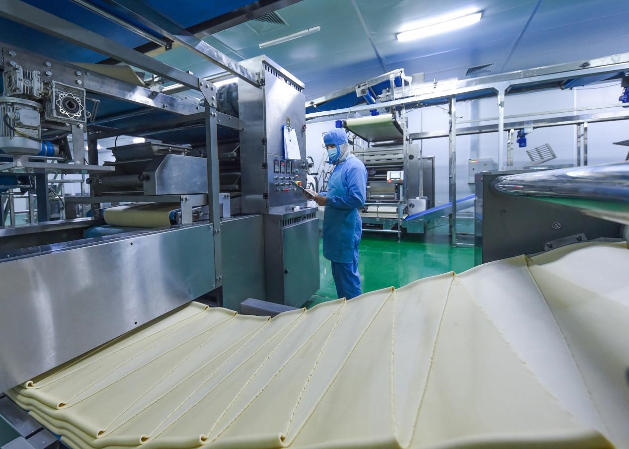 在邯郸邱县经济开发区一家食品企业,工人正在食品生产车间检查生产设备运营情况。孙海峰摄