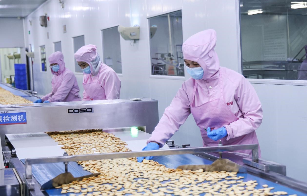 在邯郸邱县经济开发区一家食品企业，工人正在食品生产车间查看饼干生产情况。孙海峰摄