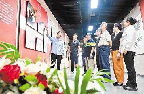 9月18日，石家庄市平山縣西柏坡村史館裡，67歲的老黨員閆上青（左一）在給游客講述西柏坡的紅色故事。本報記者 史晟全攝