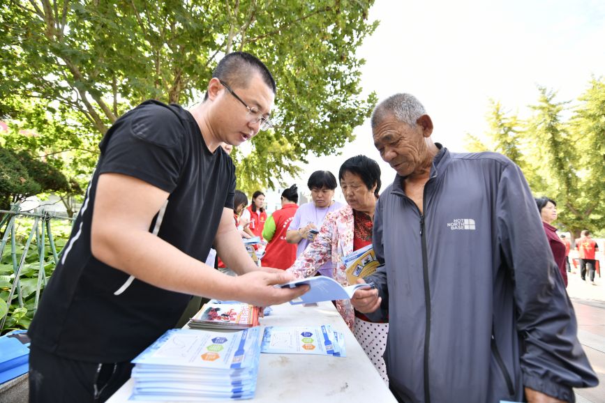 迁安市气象局志愿者向市民发放科普宣传资料。梁玉水摄