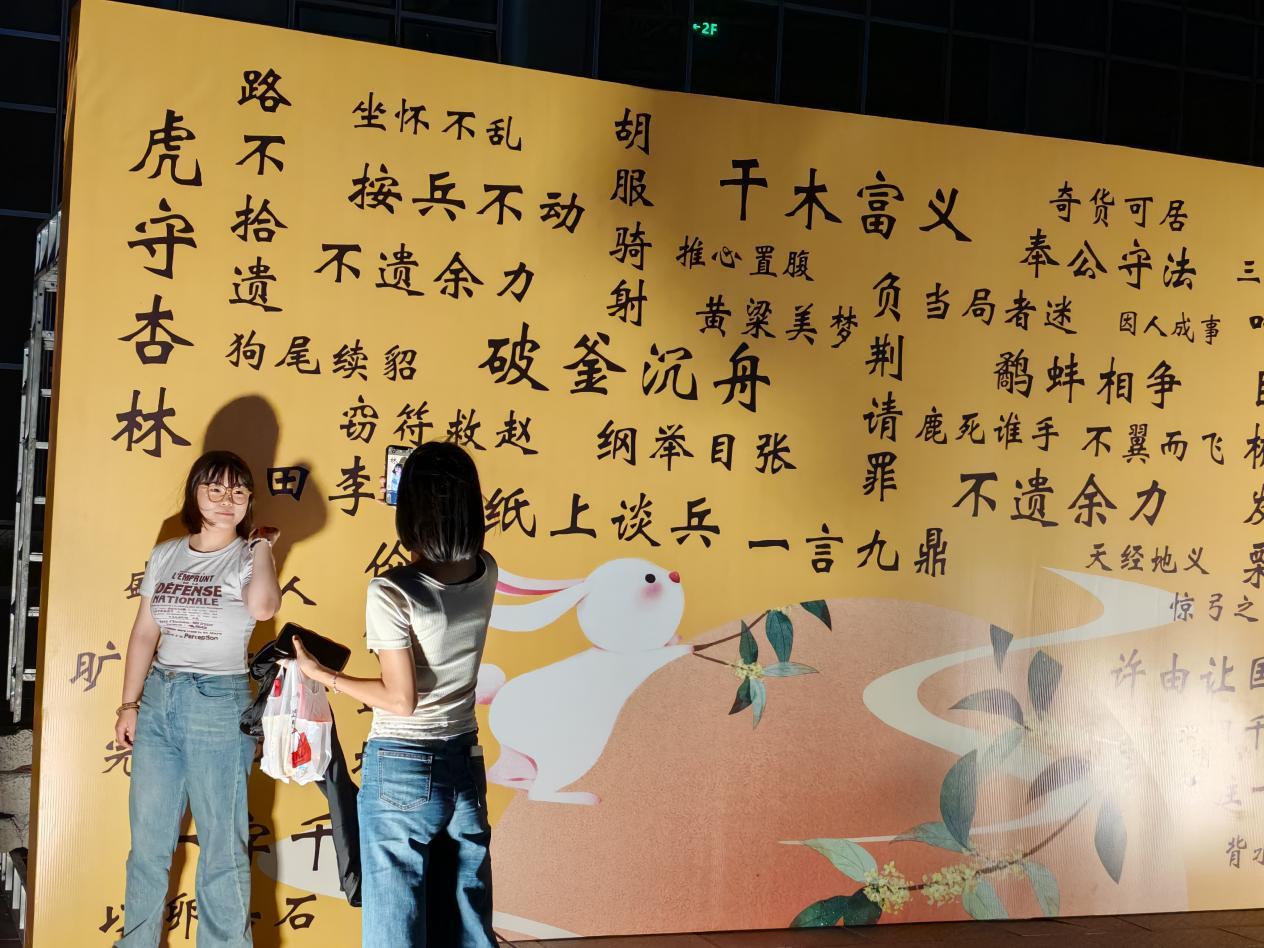 邱縣在鯤鵬國際會展中心廣場舉辦優選市集，游客在成語牆前打卡拍照。李文娟攝